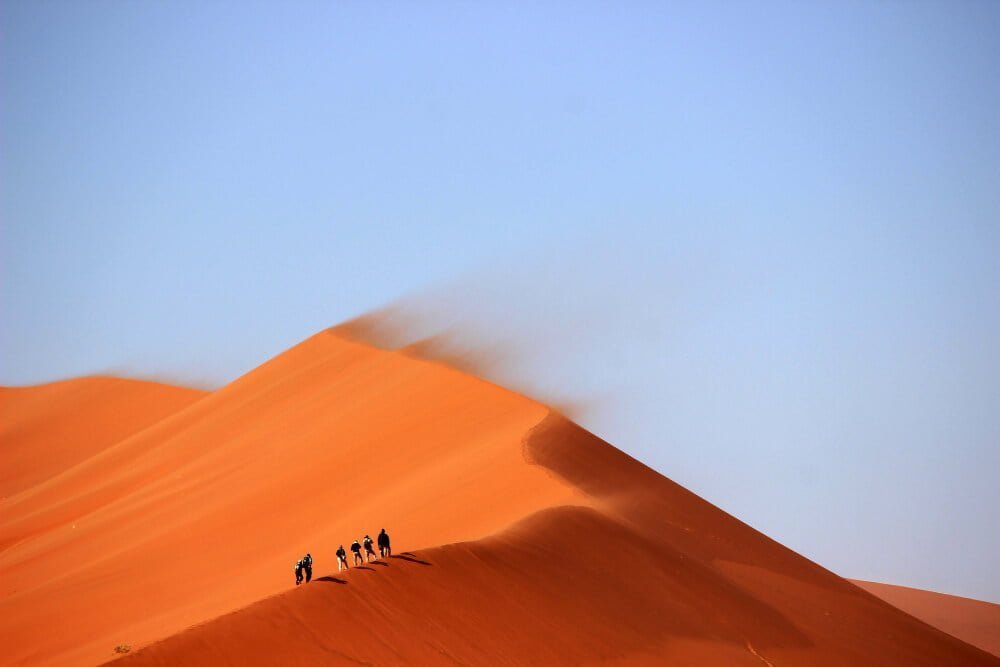tourists-climbing-up-sand